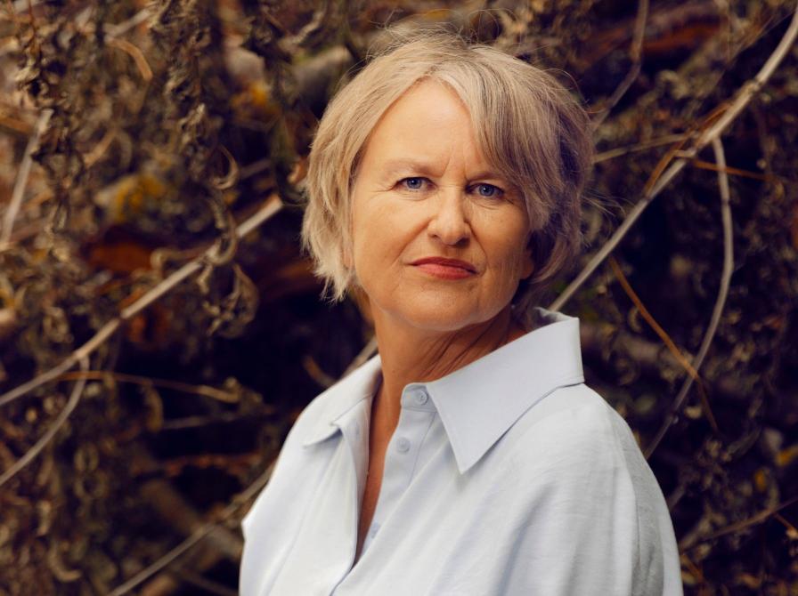 Forfatterporstræ af Ida Jessen foran nogle grene efterårsfarver